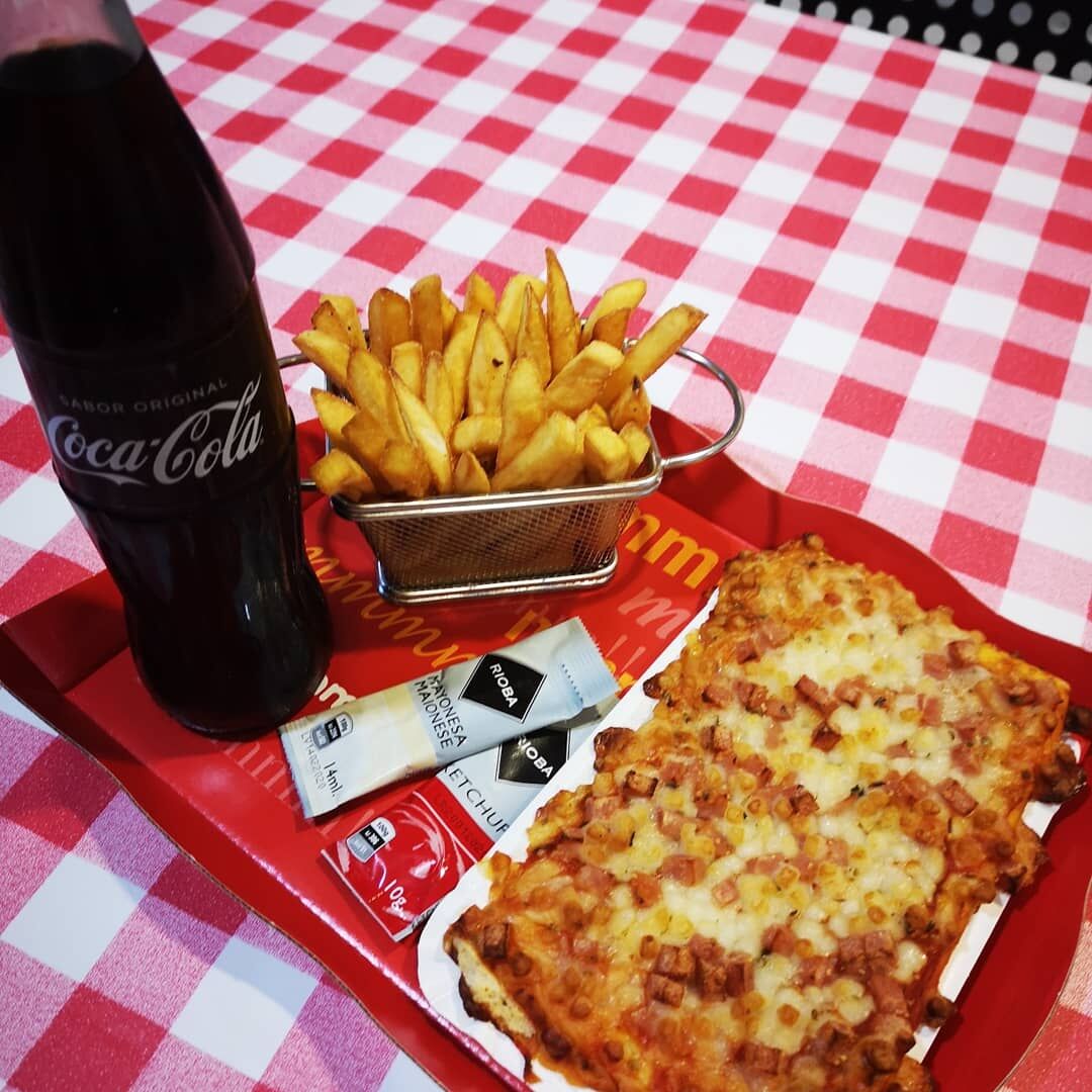 Porcion de pizza acompañada con patatas 