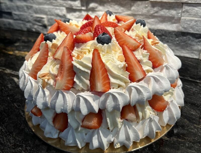 Gâteau Pavlova Fraises, Chantilly mascarpone vanille sur ses deux socles de meringue jonchées de ses fraises fraîches.