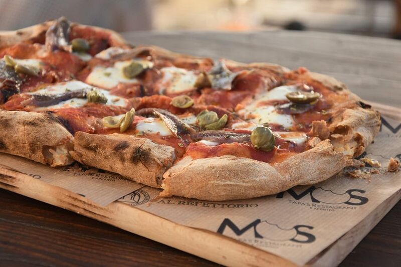 Pinsa romana, pomodoro, fior di latte, alici del Cantabrico, capperi e origano