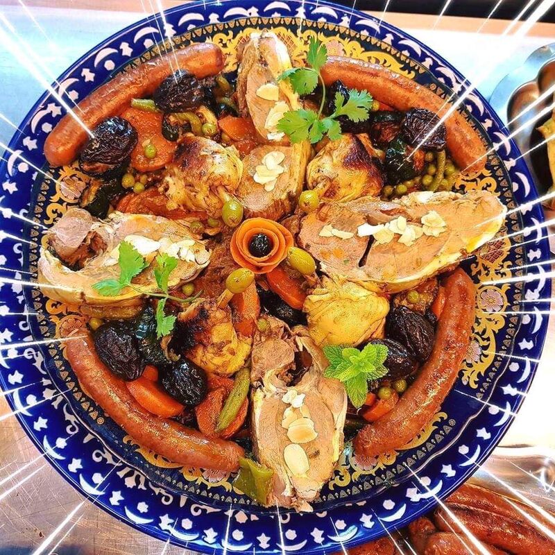 Un tajine de légumes et pruneaux accompagné de tranches d'épaule d 'agneau méchoui et merguez