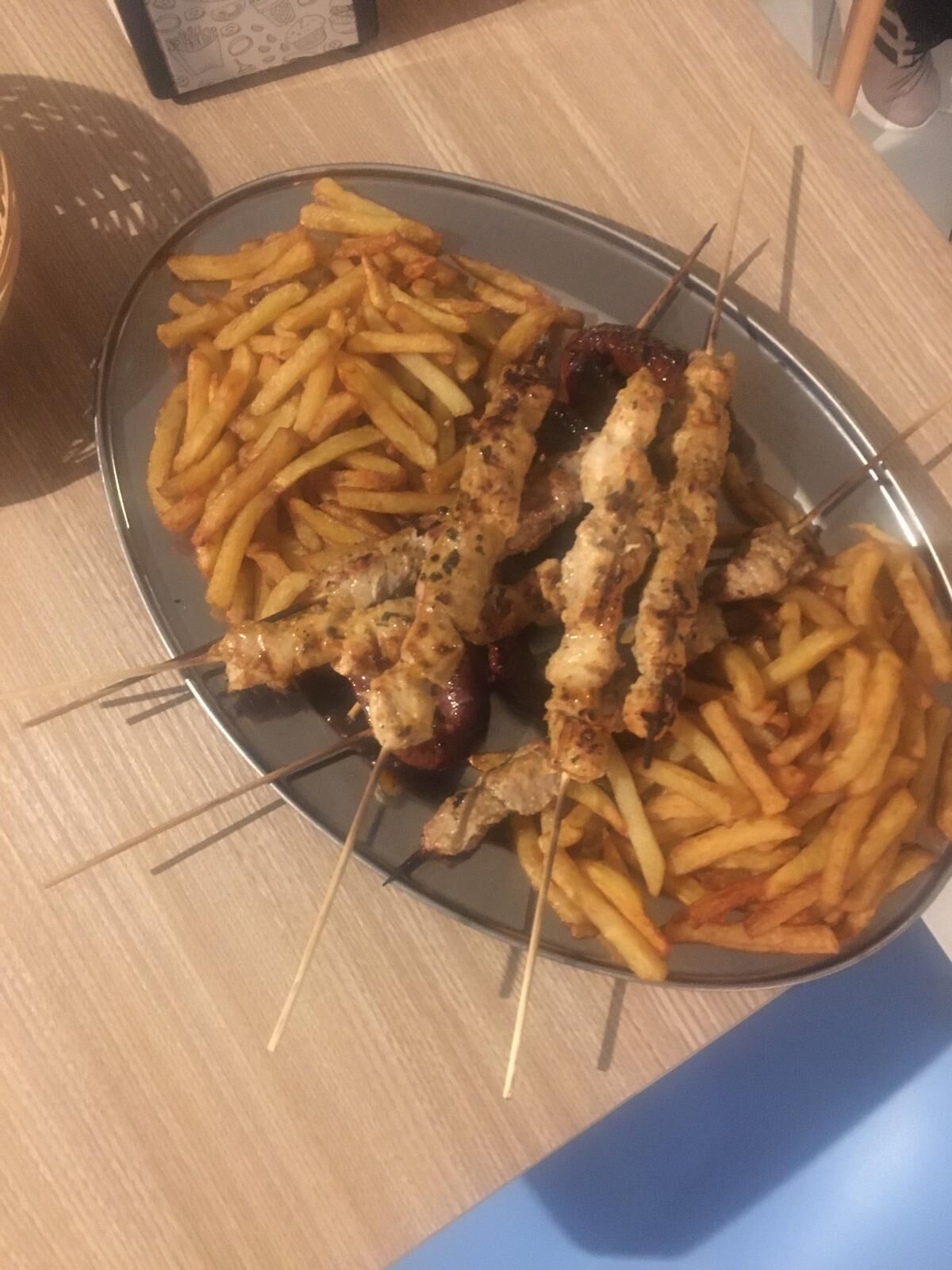Brochettes de poulet et de veau grillés au feu de bois accompagnés de frites maison