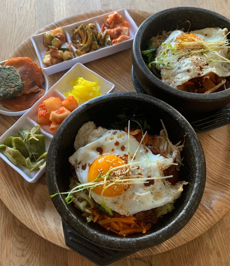 Deux Bibimbap (돌솥비빔밥) prêts à être servis dans leurs bols en pierre chaude