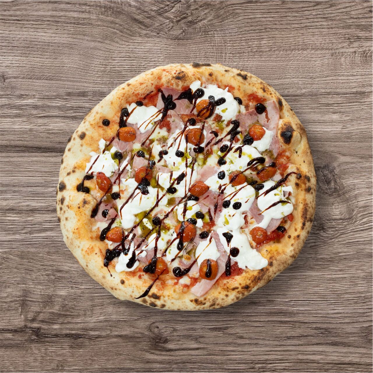 Burratina ▪ 16€ : sauce tomate bio, fior di latte, jambon, burrata, tomates cerises confites, balsamique, pesto