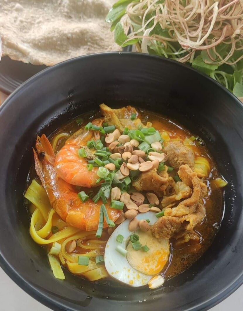 Mi Quang Rissolée d'échine de Porc aux épices et à la Citronnelle, Crevettes, œuf, sur lit de Tagliatelles de Riz au Curcuma