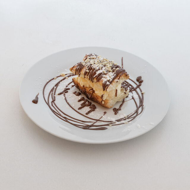 Alejandrito, ojaldre crujiente horneado, relleno de crema pastelera preparada en duetto y cubierto con chocolate.