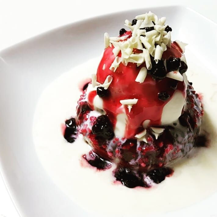 Bosque nevado con frutos del bosque fundido con chocolate blanco