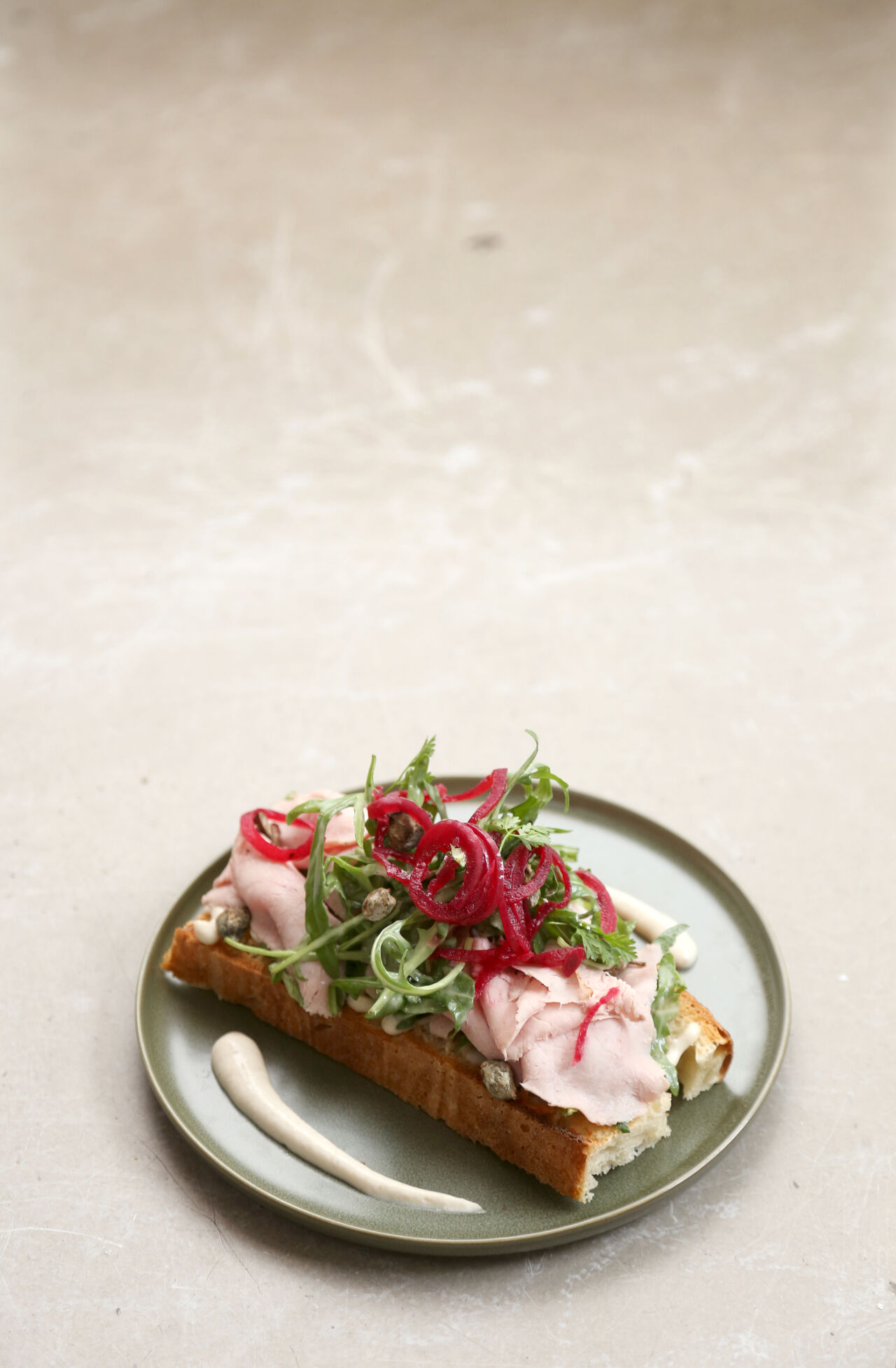 Rosa gebratener Kalbstafelspitz mit Thunfischcreme, Kapern, eingelegten roten Zwiebeln, Rauke auf geröstetem Brot