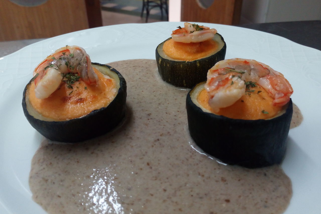 Calabacin relleno de crema fina de langostinos con salsa de Hongos
