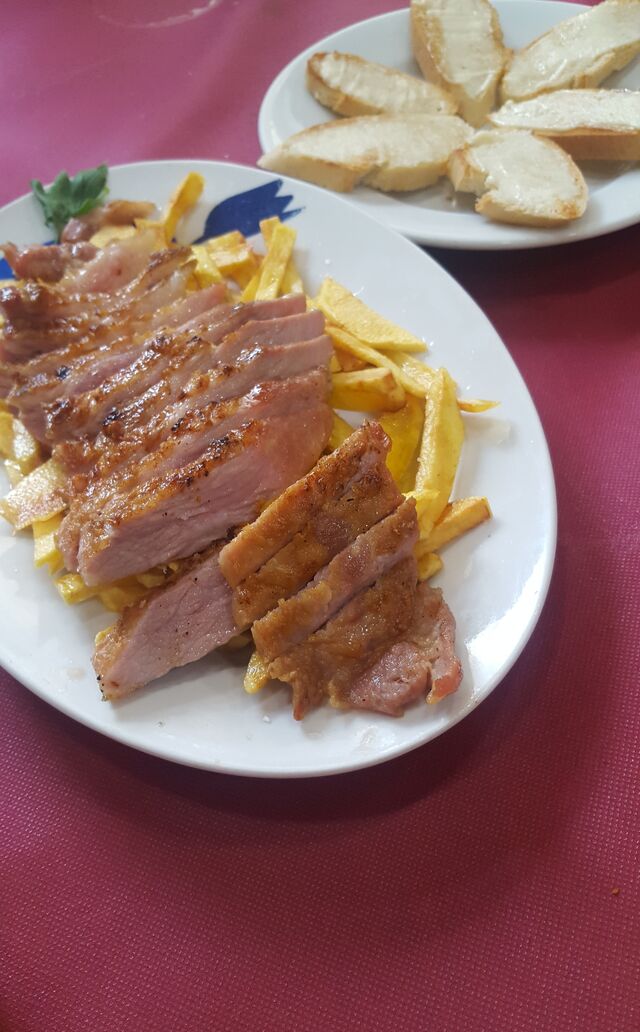 Secreto a la plancha en cama de patatas.