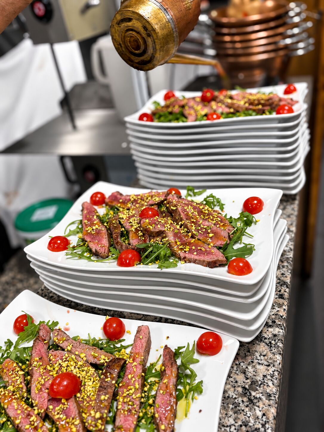 Tagliata di filetto di manzo con rucola,pachino,pistacchio e scaglie di Parmigiano Reggiano