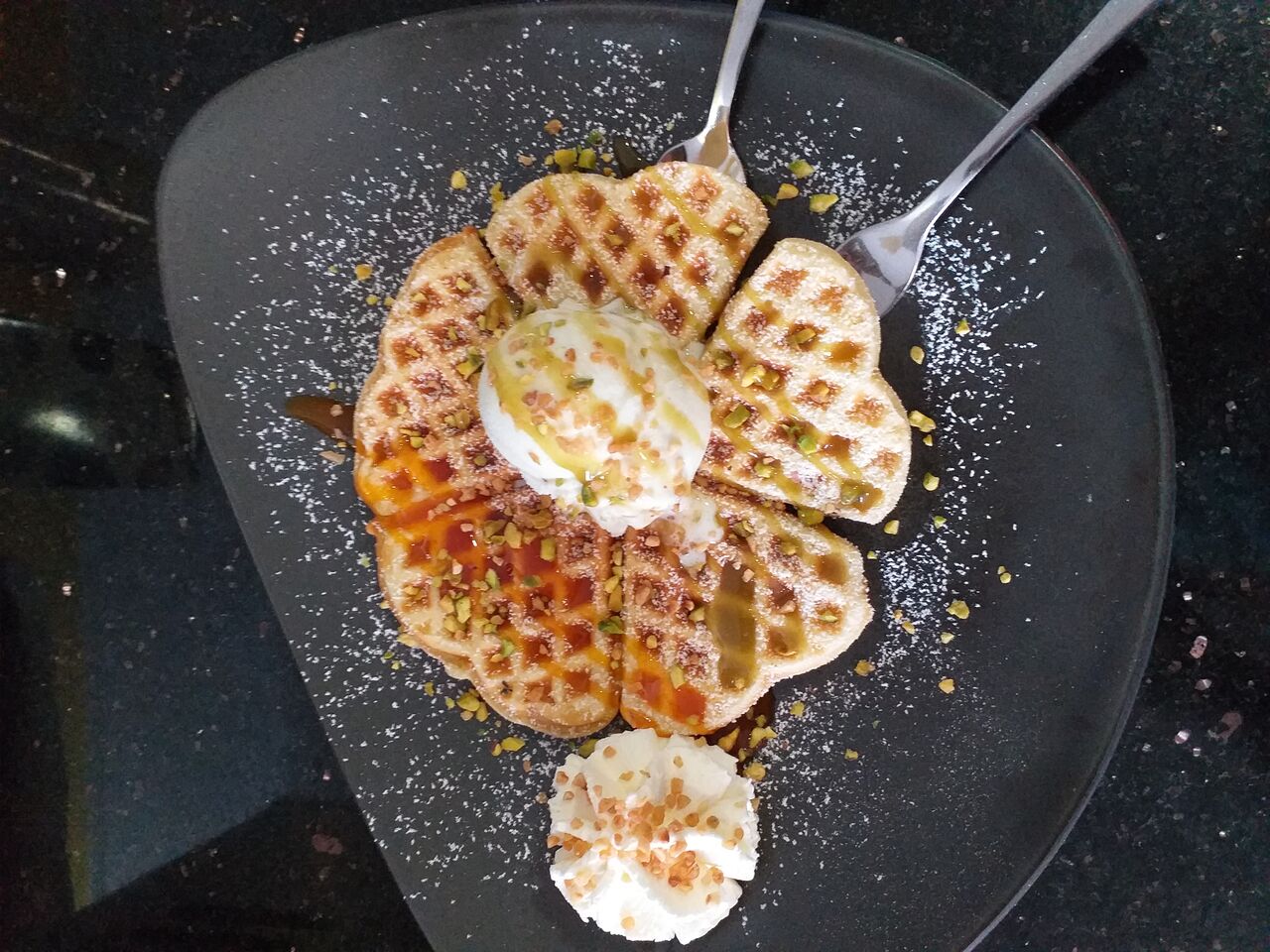 Heiße Waffel mit Siciliano Eis, Pistaziensoße, gehackten Pistazien und Sahne