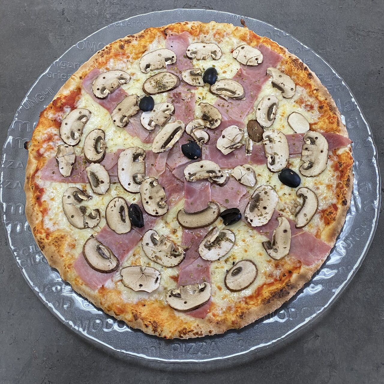 Pizza Reine:
Sur fond de tomate, Mozzarella, jambon, champignons frais, olives, origan