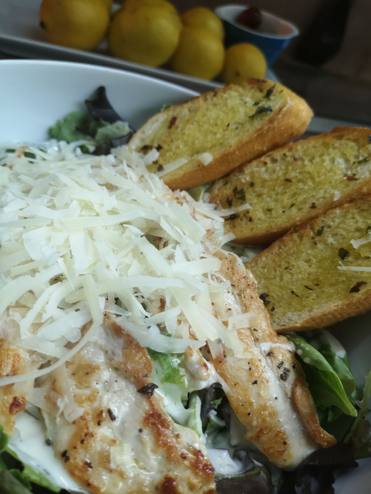 Ensalada Cesar con pechuga de pollo a la plancha acompañada con pan de ajo recién tostado