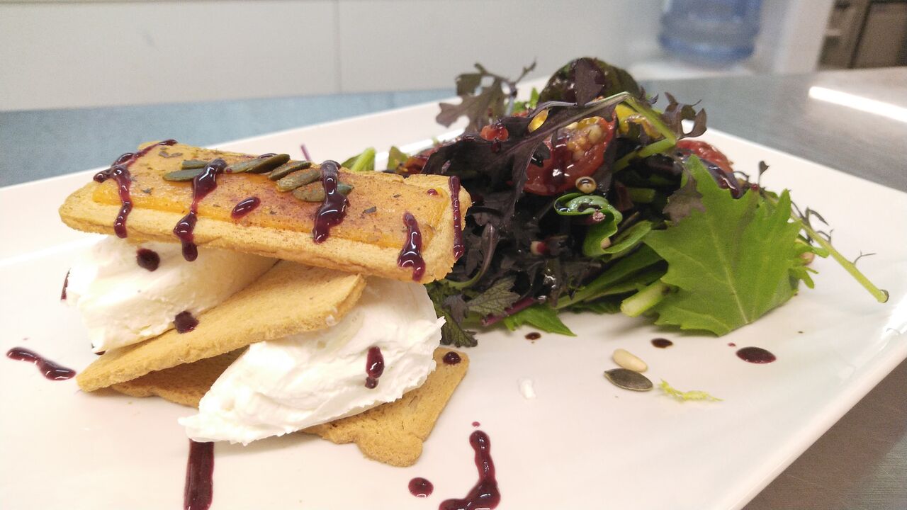 Ensalada de cremoso de cabra con naranja,tomate, frutos secos y salsas de la casa