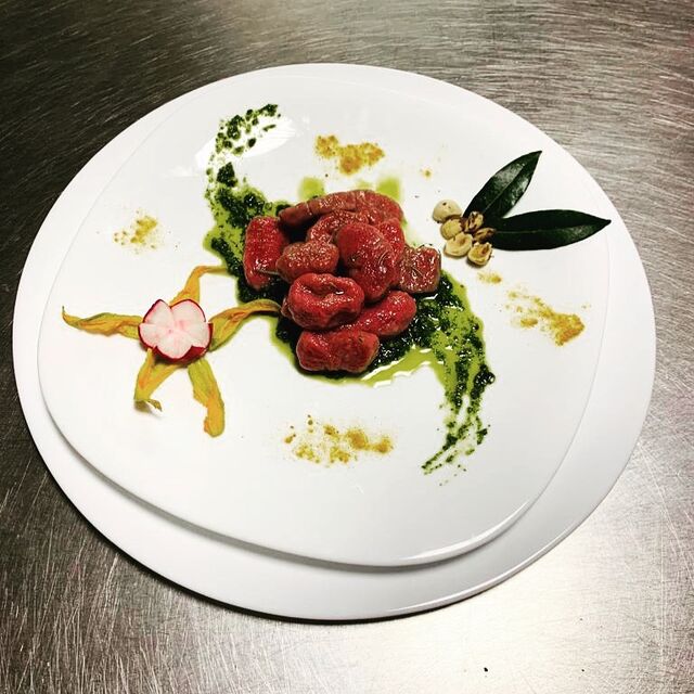 Gnocchi fatti a mano di barbabietole su letto di pesto di rucola e nocciole