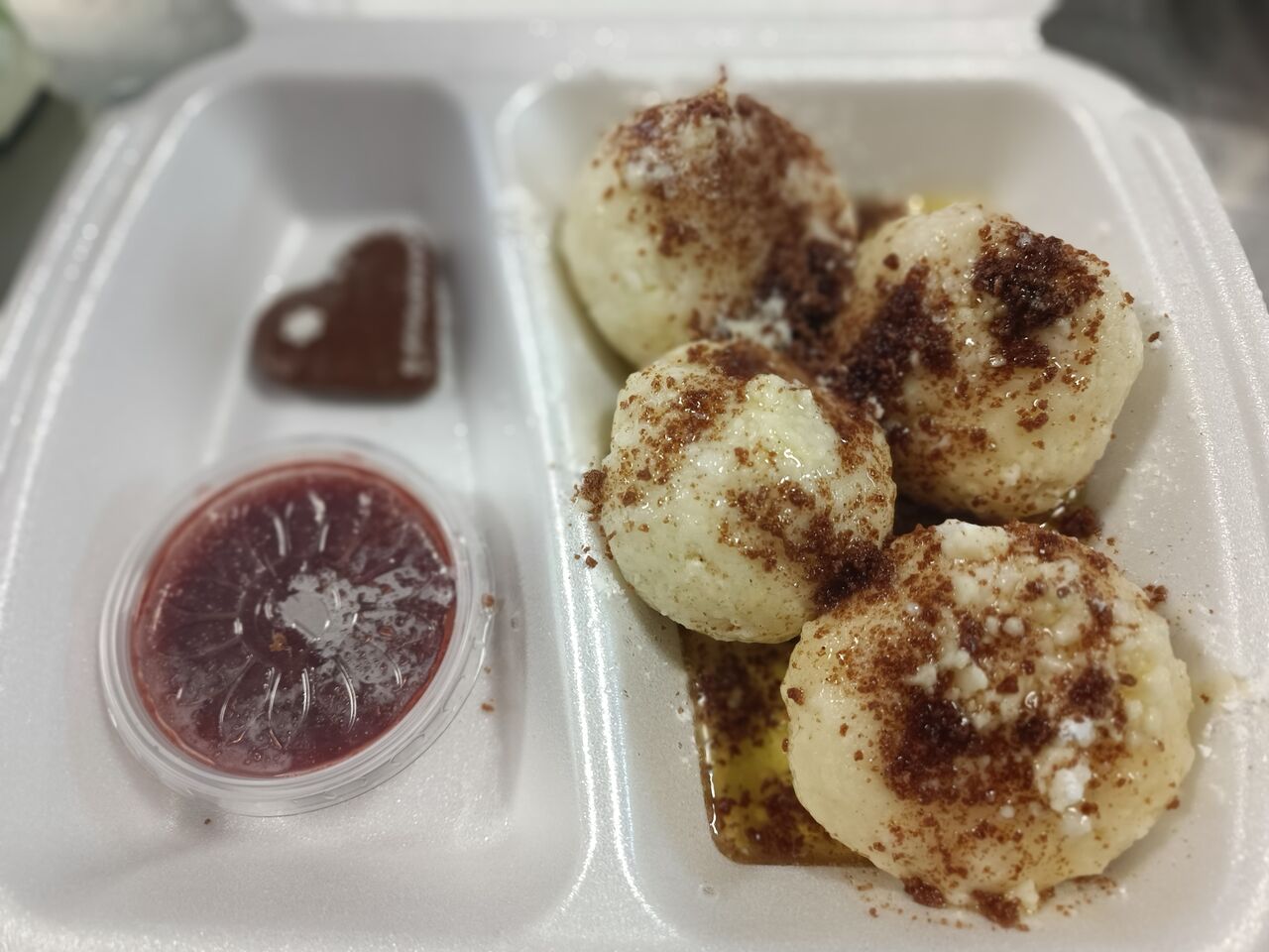 švestkové, tvarohové knedlíky sypané perníkem, máslem a cukrem se švestkovým rozvarem