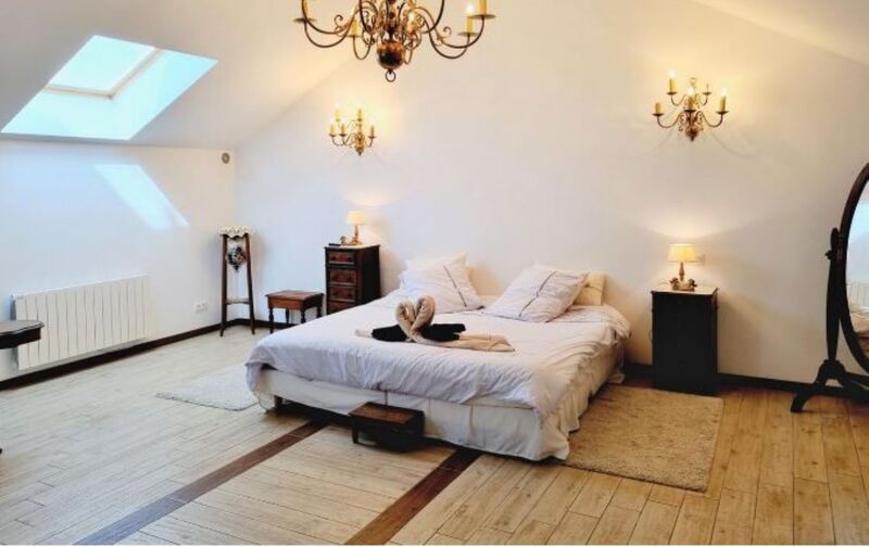 Suite nuptiale de 100 m² à l'étage avec un lit en 200x200. Baignoire design et douche atypique au cœur du pigeonnier. 