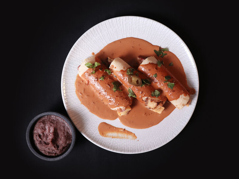ENCHILADA MUY AMIGOS
(Tortilhas de milho recheadas com chouriço, batatas, ovos, e queijo cobertos com molho de chili ancho).