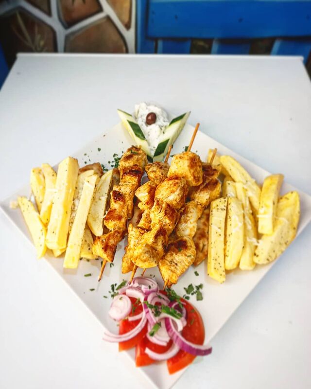 Kalamaki kotópulo: 3 brochetas tiernas de pollo marinado con tzatziki, tomate, patatas fritas caseras y pita. 