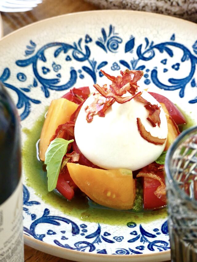 Burrata with a variety of tomatoes and pesto sauce