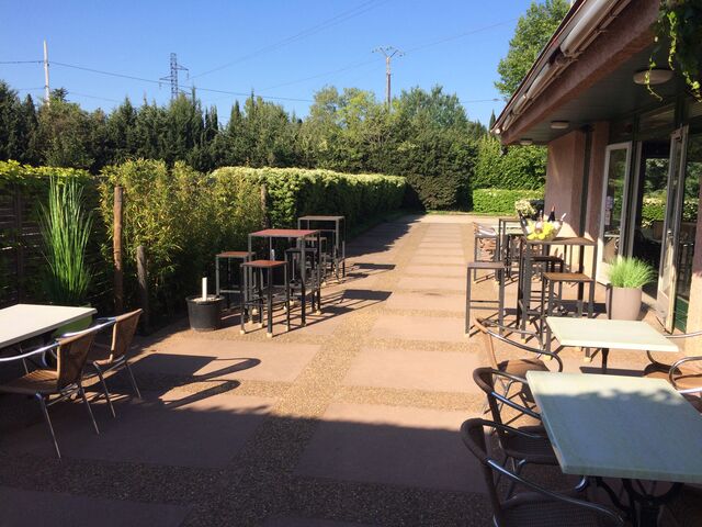 Une terrasse ensoleillée avec store et parasol...