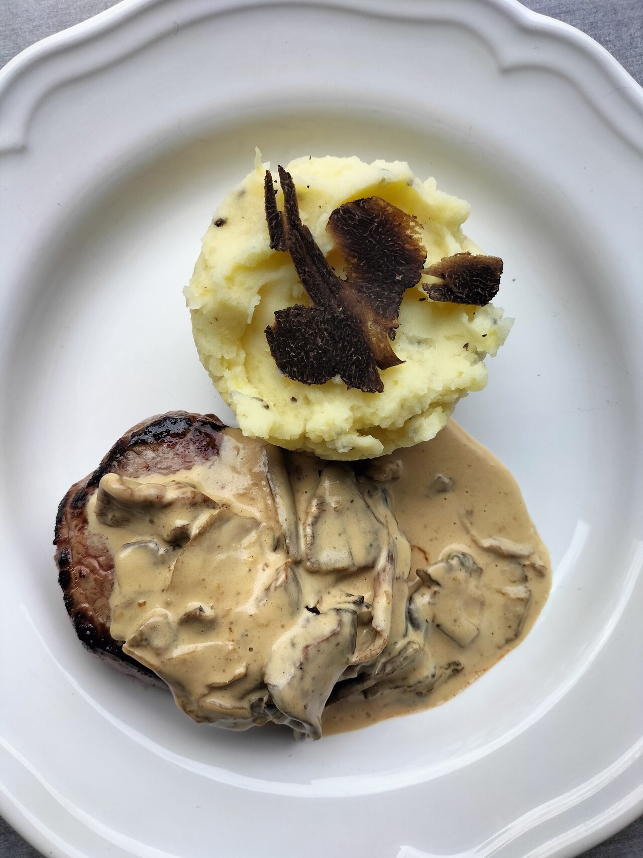 Pavé de bœuf accompagner d'un écrasé de pommes de terre à la truffe sauce aux cèpes.