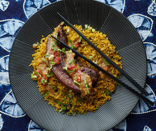 Poitrine de porc infusée dans bain d'herbes et d'épices accompagnée de sa sauce banane et de riz doré sauté.