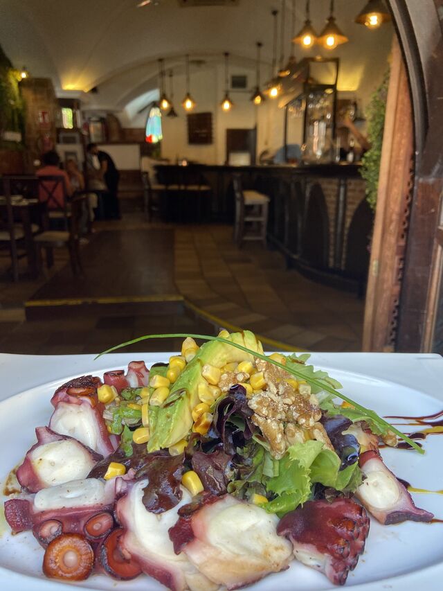 Pulpo braseado con lechuga fresca del huerto tomate cherry y aguacate