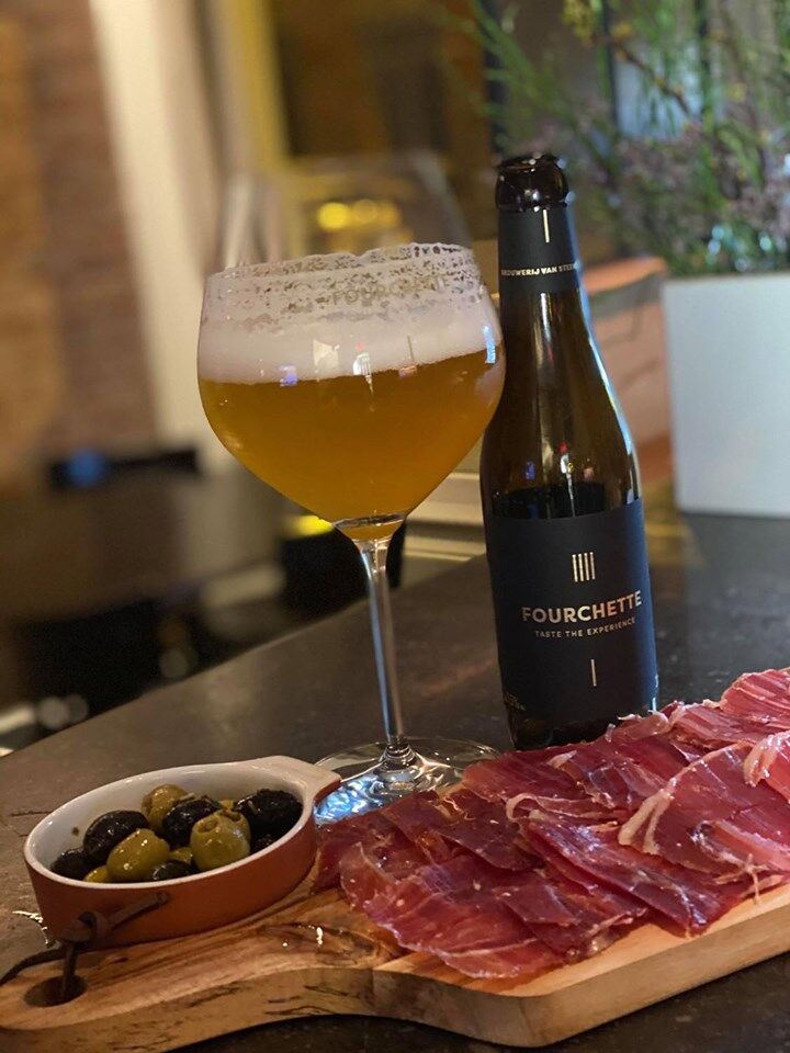 Een plankje handgesneden Iberico ham, olijven en een Fourchette Bier.
