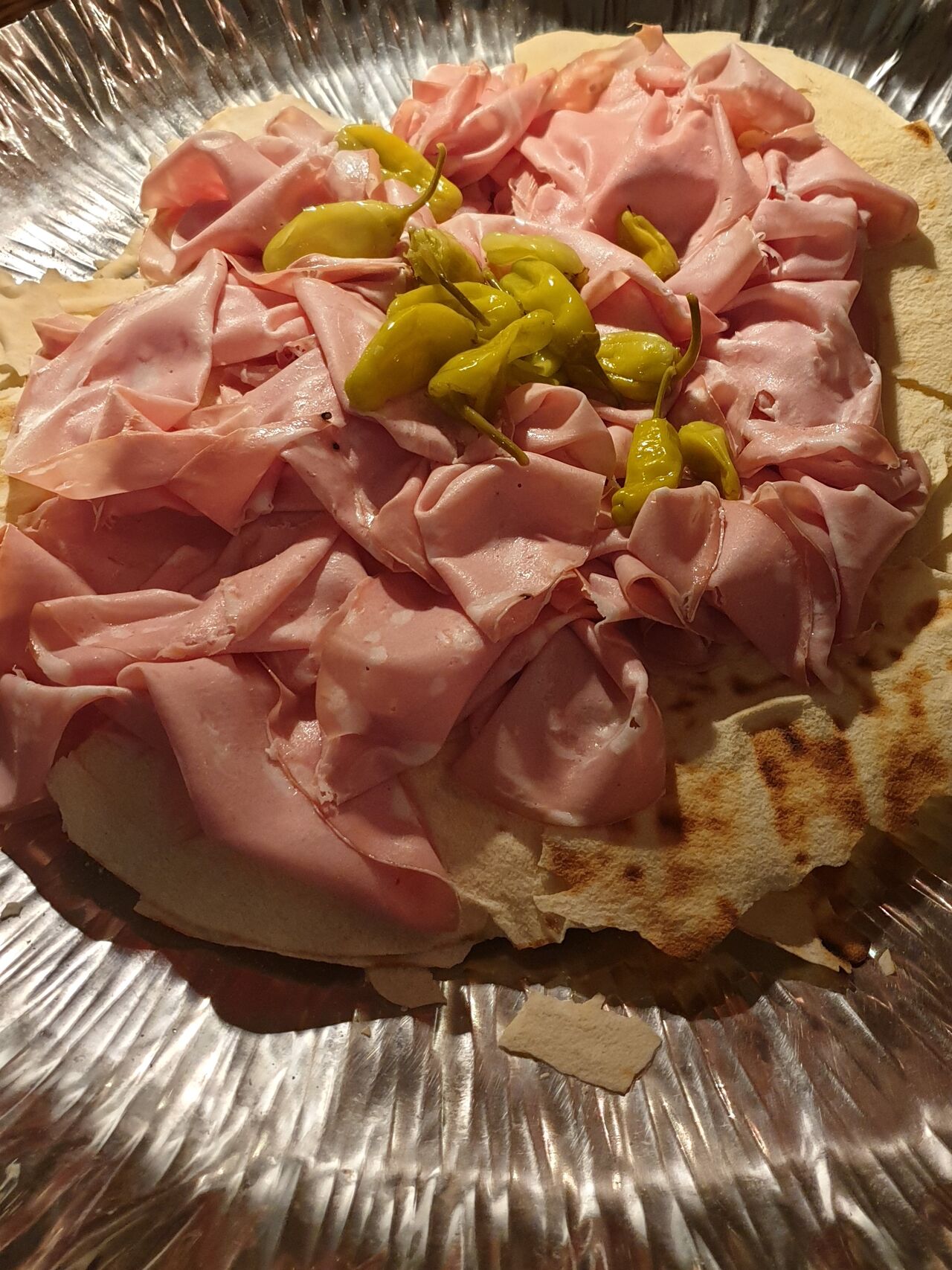 La mortadella di Scapin il pane carasau e i peperoncini verdi