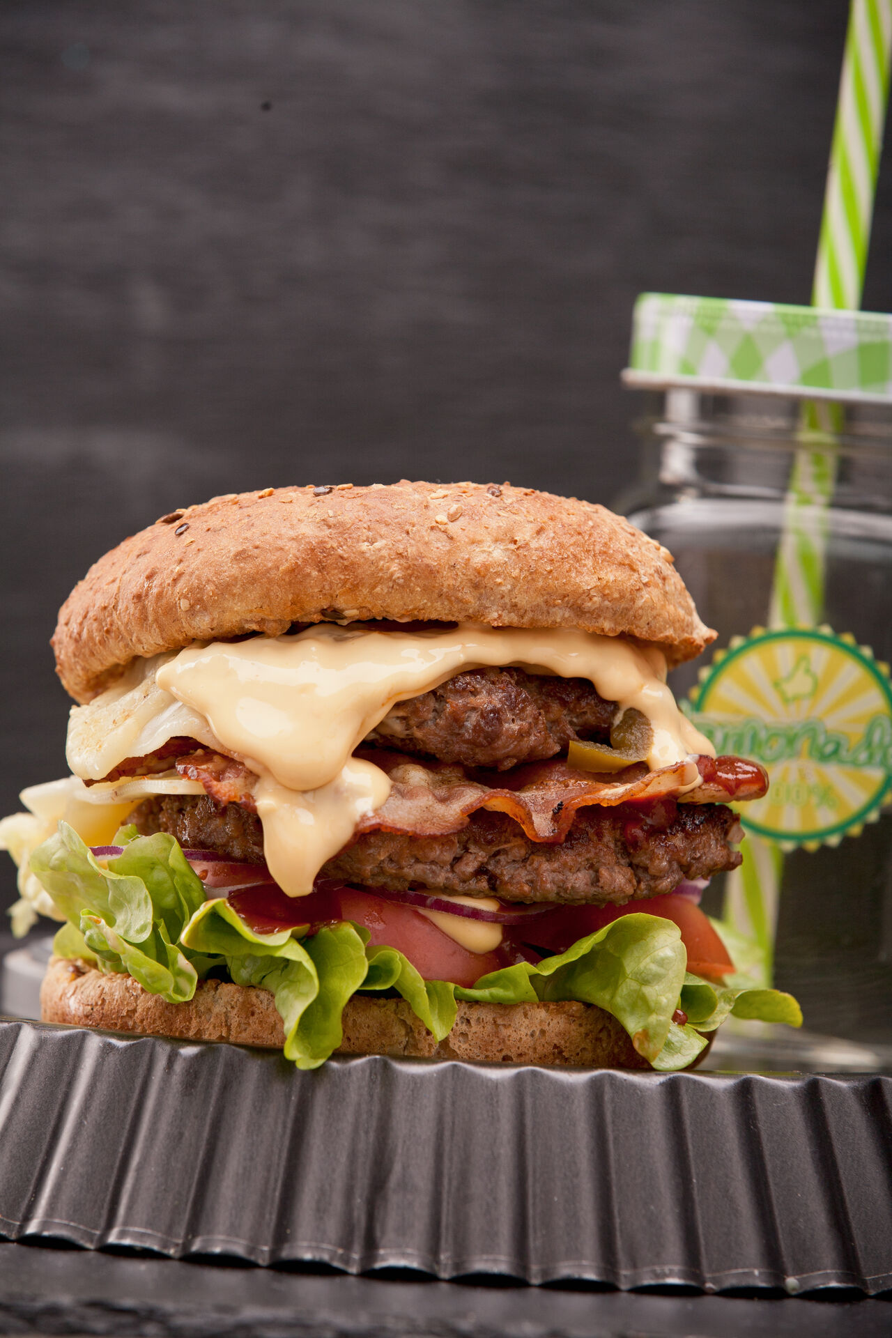 Double Beef Burger: 2xBeef, 2xKas, 2xBacon, Jalapeños, Tomaten, Zwiebeln, Käsesoße und scharfe BBQ Sauce