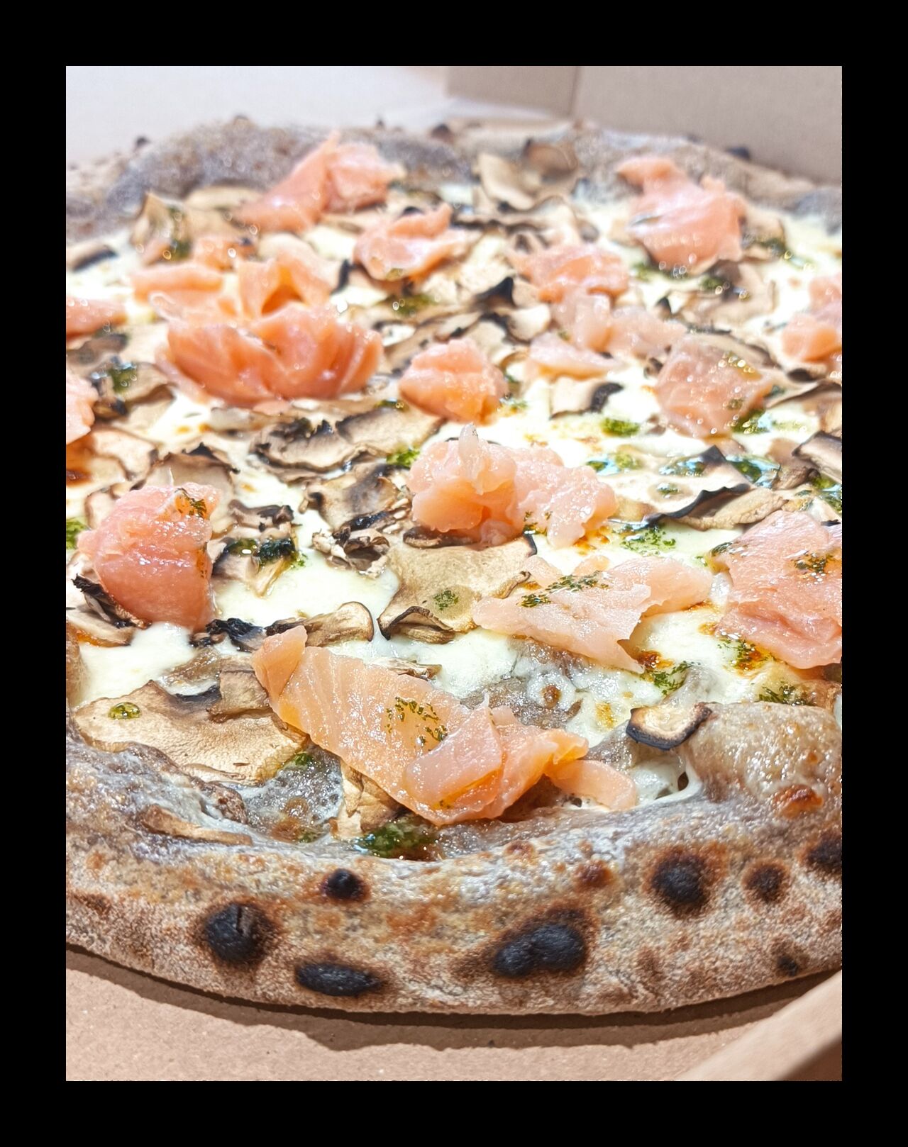 Pizza Salmone - Base crème, mozza FDL, champignons, après cuisson: saumon fumé et sauce aneth maison 