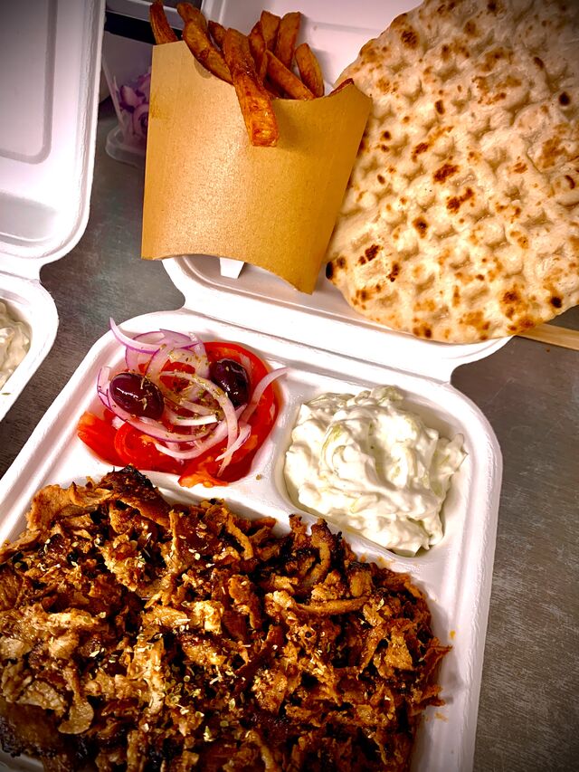 Assiette gyros accompagnée d’une barquette de frites. 