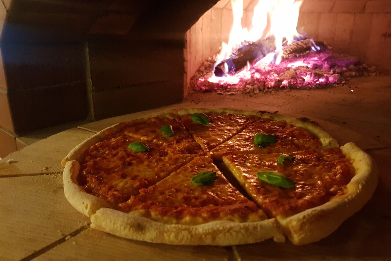 Pizza Włoskiej tradycyjnej receptury z pieca opalanego drewnem