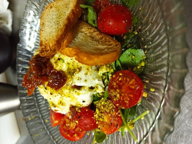 Ensalada de Burrata, tomate seco, tomate cherry, rúcula y polvo de pistacho