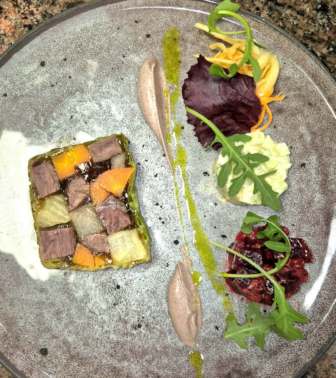 Interprétation d’un bœuf gros sel, servie en gelée, petits légumes de printemps et condiment de moutarde violette.