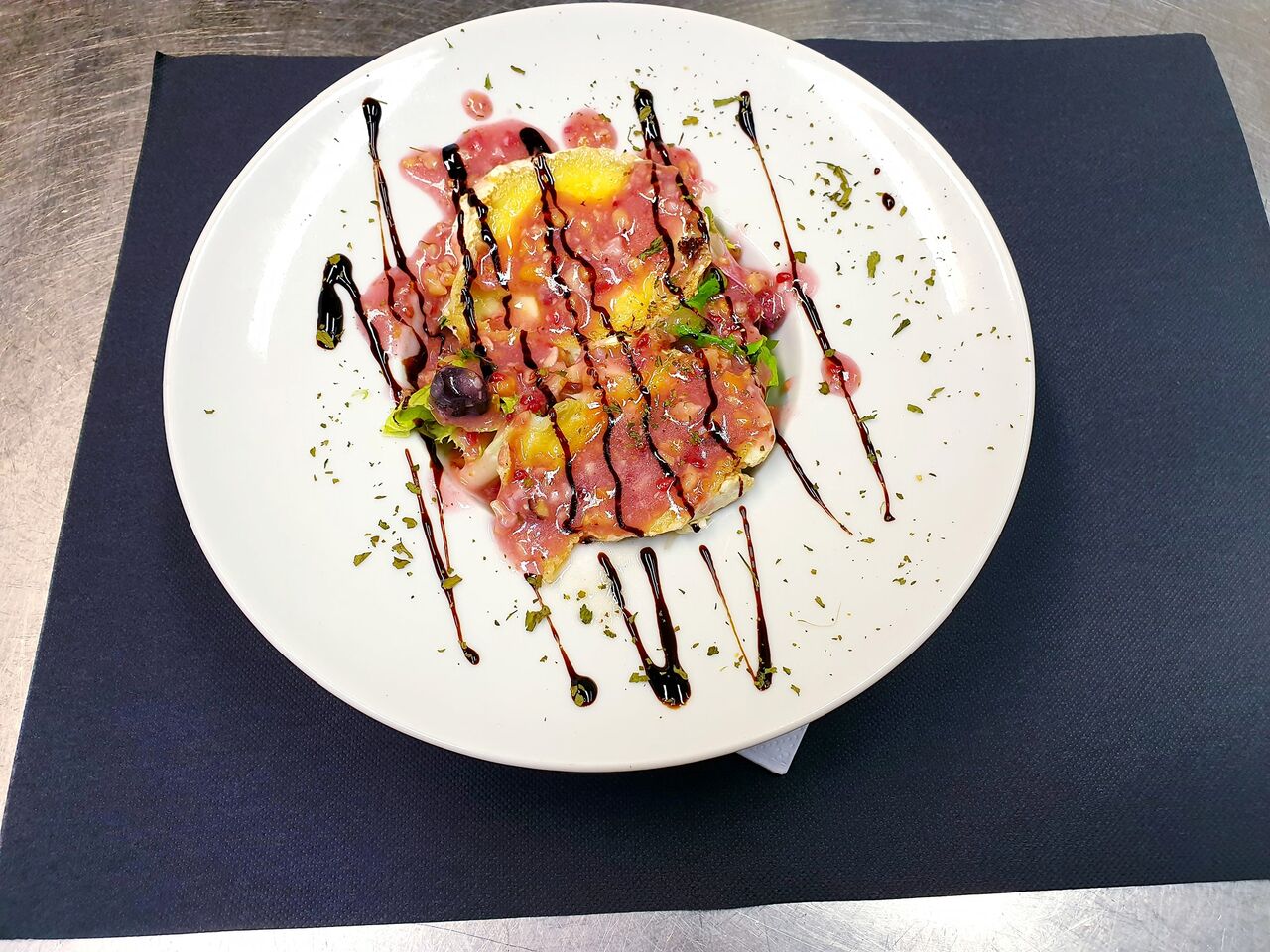Ensalada de queso de cabra semi fundido en la plancha con vinagreta casera de frutos secos y rojos.