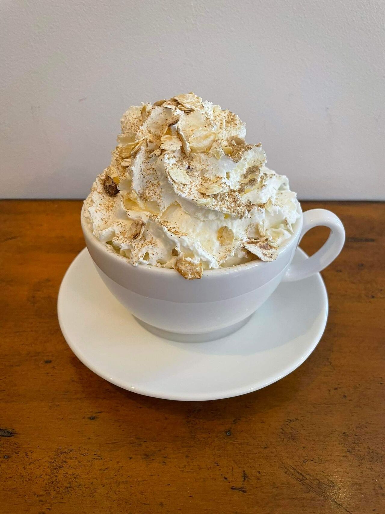 Dynia w miodzie-kawa z syropem dyniowo-miodowym, bitą śmietaną, płatkami kasztanowca i cynamonem.