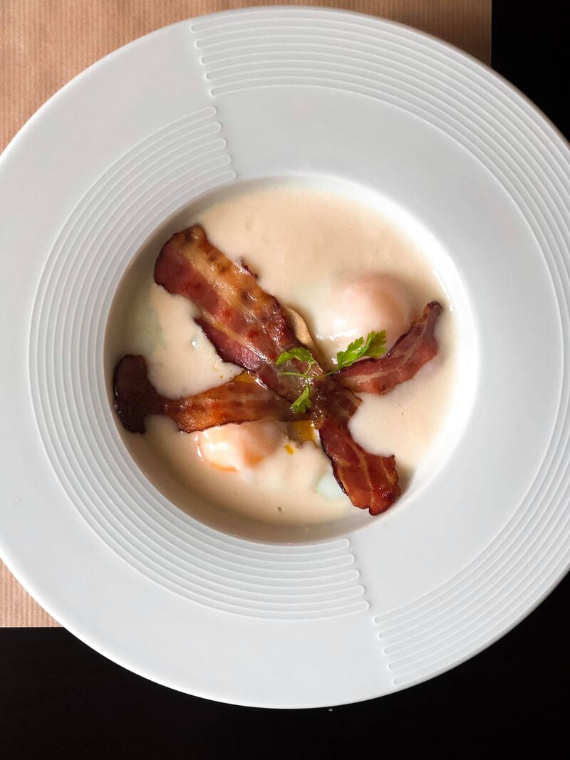 Oeufs coulants à 64° à la crème d'asperges et chips de lard fumé