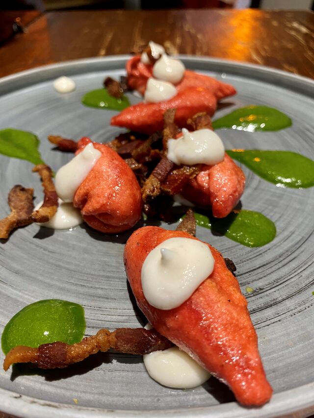 Primi: Culurgiones Scottati, pesto di Rucola, guanciale croccante e crema di fiore sardo