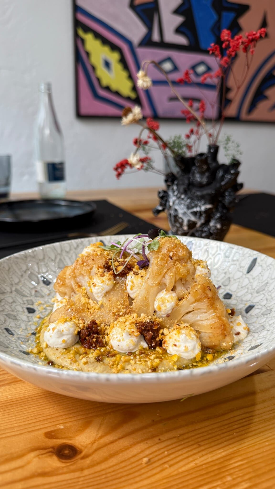 Coliflor a baja temperatura y gratinada con char siu,hummus,salsa de sésamo,harisa y polvos de kikos