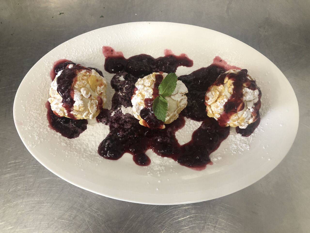 Hideg túrógombóc ropogós cornflakesbe forgatva, erdeigyümölcs mártással