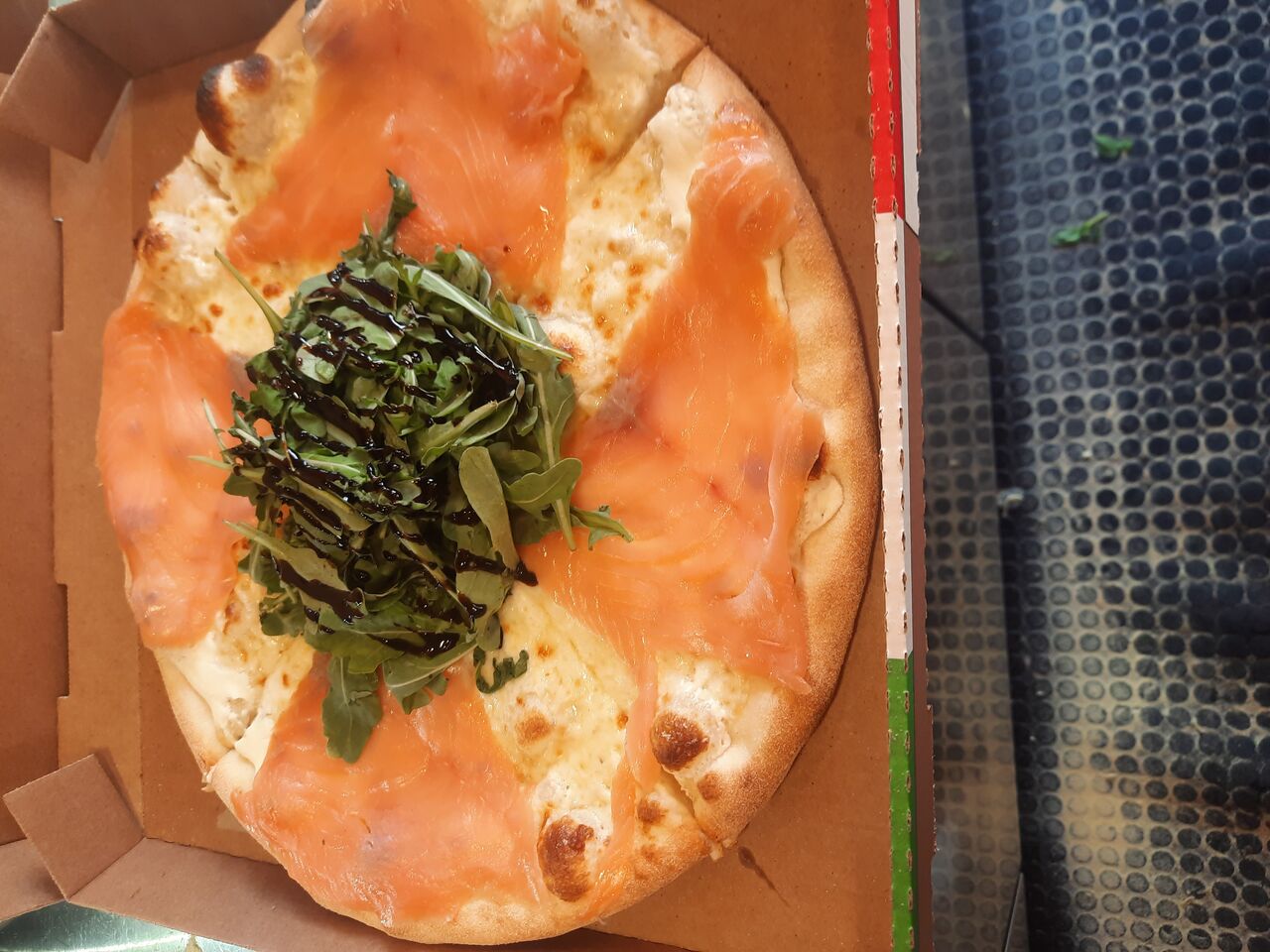 pizza saumon fumée, base crème ,mozzarella Fiore di latte roquette poudre de pistache, crème balsamique