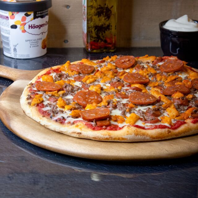 LA CARNIVORE : sauce tomate, jambon, mozzarella, merguez, poulet tikka, viande hachée, origan.