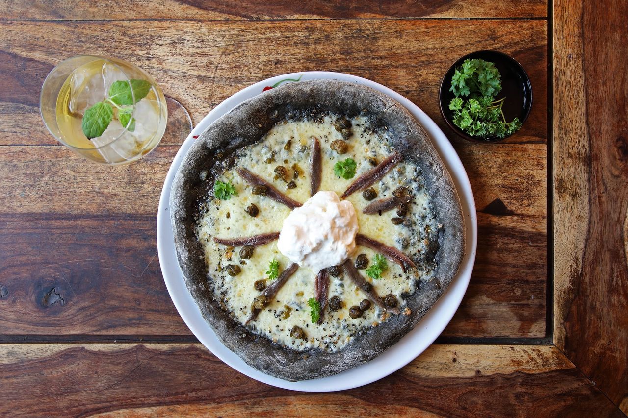 THE BLACK ALICIONA
Squid ink dough_
Mozzarella, anchovis, stracciatella cheese, capers & fresh herbs