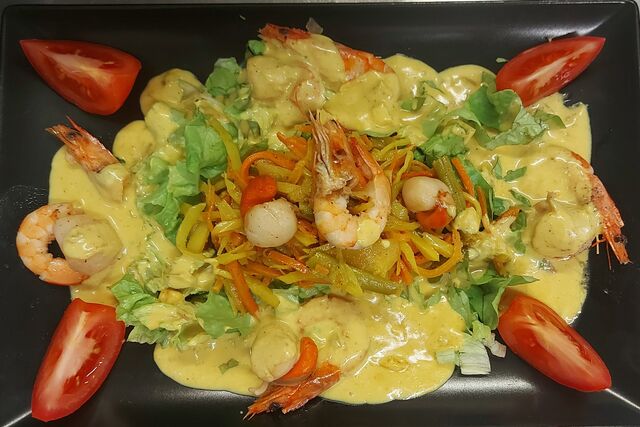 Flambée de noix de saint Jacques et crevettes, sauce coco curry au rhum.