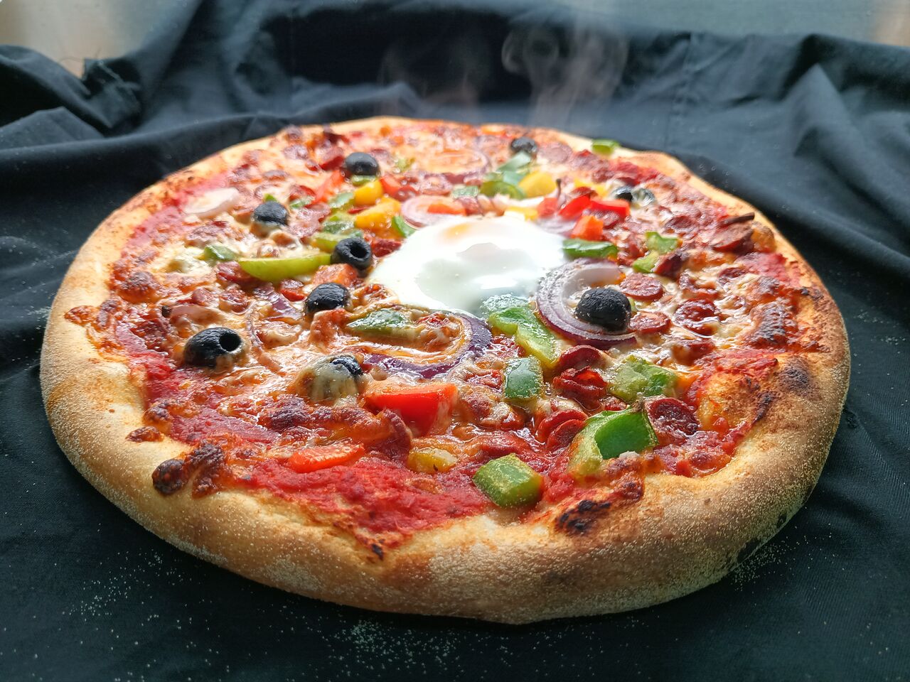 L'Orientale: base tomate, mozzarella,merguez, oignons rouges, poivrons, olives, oeuf