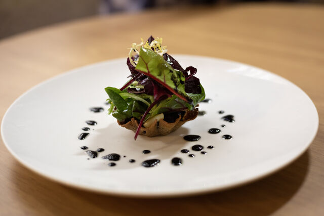 Tartelette sarrasin-boudin noir, salade croquante et seiches, vinaigrette à l’encre de seiche