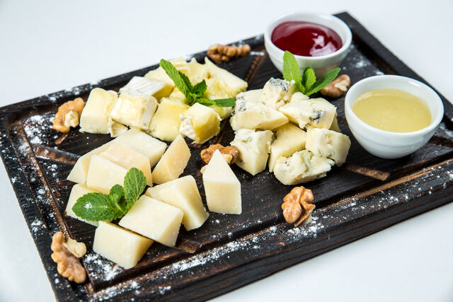 Сирна тарілка з медом та вишневим соусом.