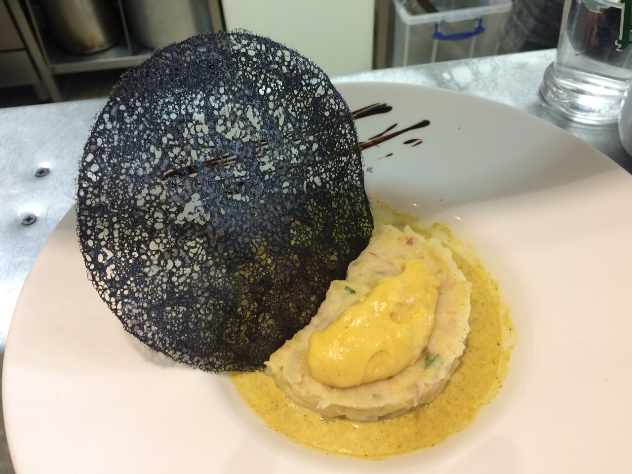 Brandade de dorade au jus clarifié de crustacés, crème de rouille, galette de parmesan à l'encre de seiche